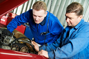 Mechanics adjusting spark plugs